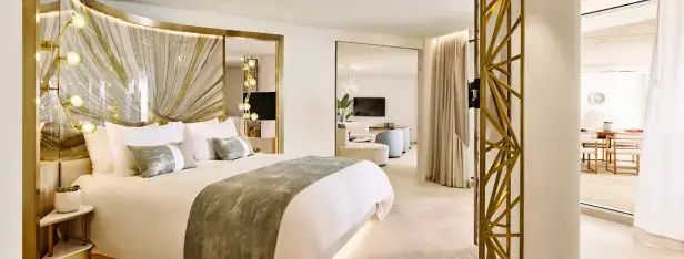 Elegantes Schlafzimmer mit großem Bett und Blick auf den Wohnbereich. Helle und moderne Einrichtung.