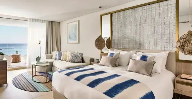 Geräumiges Schlafzimmer mit blauen und weißen Akzenten und gemütlichem Sofa. Moderne Dekoration.