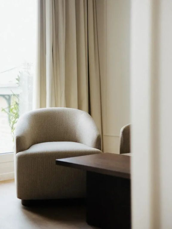 Eleganter Loungesessel vor einem großen Fenster in der Suite