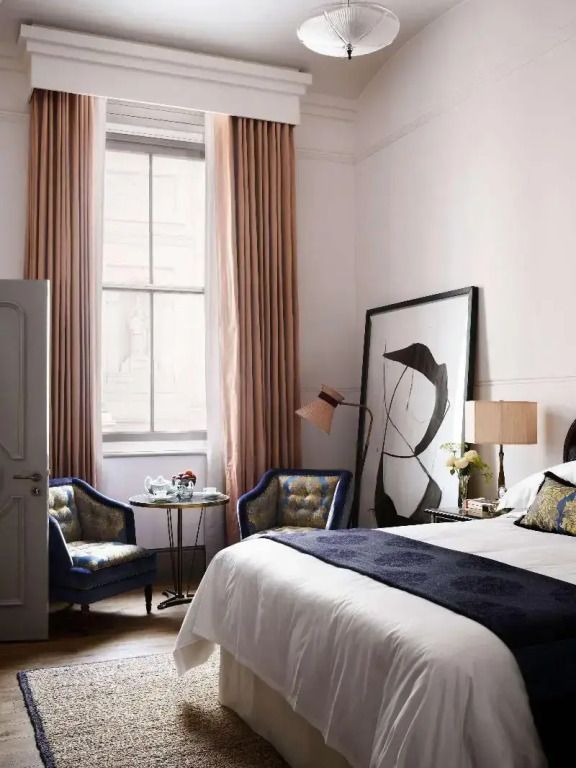 Helles Doppelzimmer mit großem Fenster, Kingsize-Bett und Sitzbereich im NoMad London.