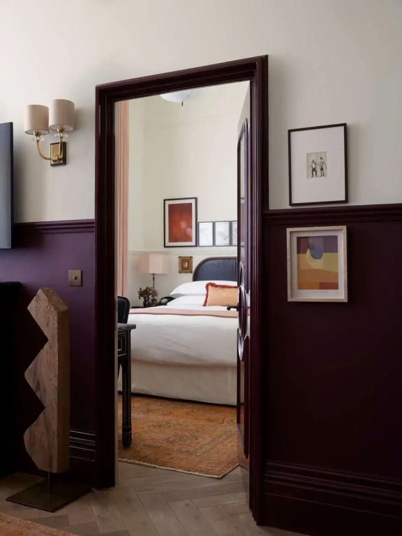 Durchgang zu einem hellen Schlafzimmer mit Kunst an den Wänden im NoMad London Hotel