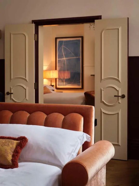 Elegantes Schlafzimmer einer Suite mit stilvollem Interieur und Kunstwerk