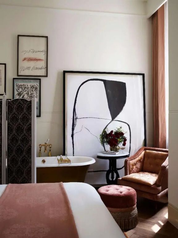 Komfortables Schlafzimmer mit freistehender Badewanne und künstlerischem Flair