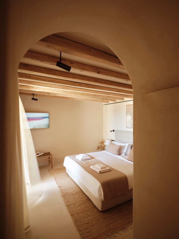 Helles Schlafzimmer mit Holzbalkendecke und Kunst an der Wand