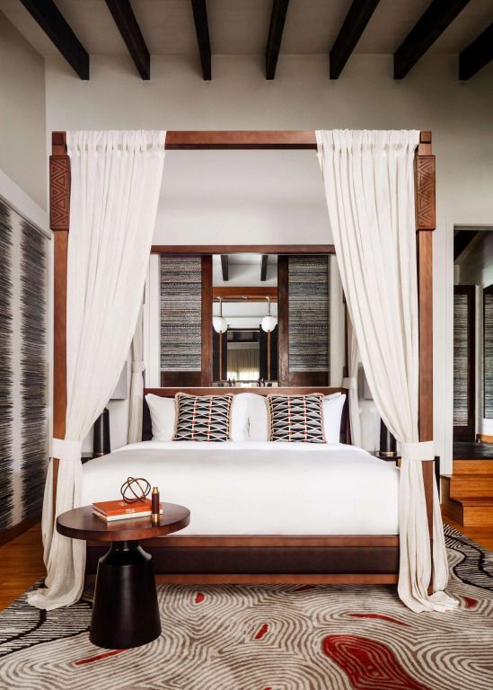 Luxuriöses Himmelbett mit dekorativen Kissen in einem eleganten Hotelzimmer