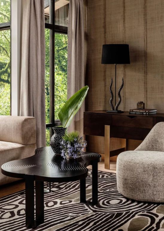Elegantes Wohnzimmer mit moderner Einrichtung, Pflanzen und großen Fenstern.