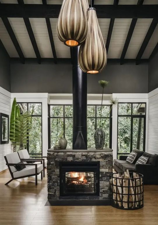 Geräumige Lounge mit modernem Kamin und hohen Decken mit dekorativen Lampen.