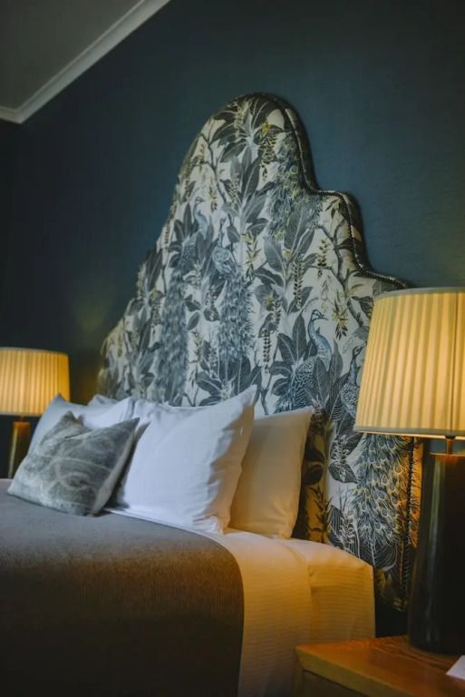Detailaufnahme des Bettes mit kunstvollem Kopfteil im Deluxe Doppelzimmer.