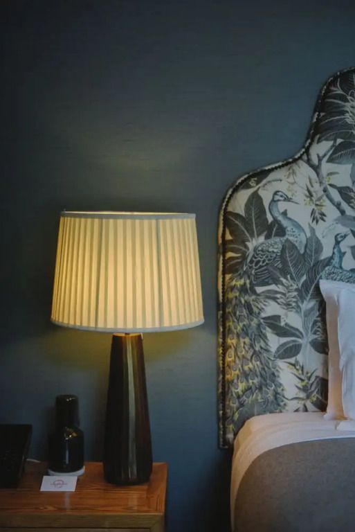 Detail des Nachttisches mit dekorativem Polsterbett im Deluxe Doppelzimmer.