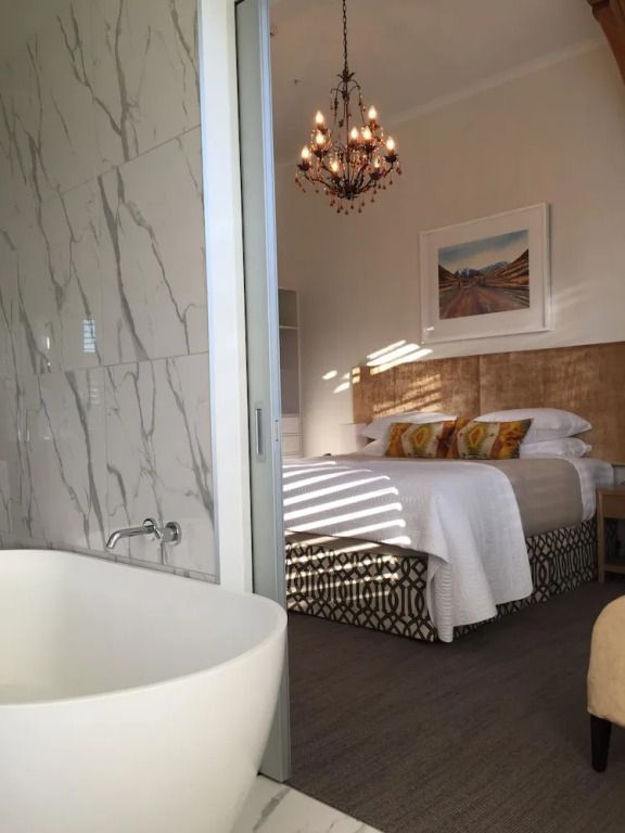 Blick ins Premium Doppelzimmer mit Marmorbadewanne und elegantem Kronleuchter