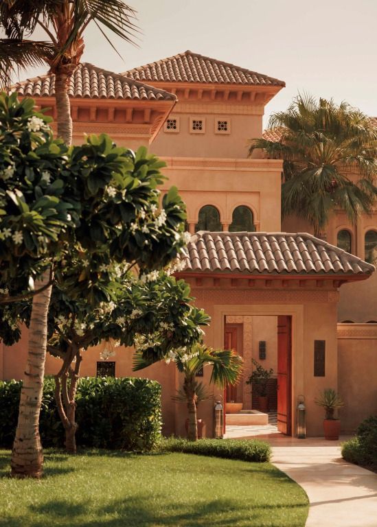 Eingang zu einer prachtvollen Villa mit traditioneller Bauweise und üppigem Grün