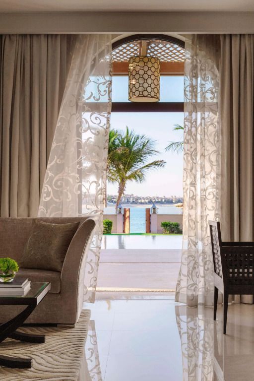 Wohnbereich mit Blick auf den Strand durch dekorative Vorhänge im Hotel One&Only The Palm.
