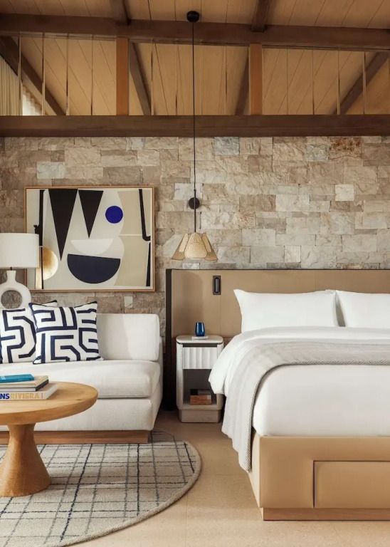 Elegantes Doppelbett mit moderner Kunst an der Wand und stilvollen Kissen