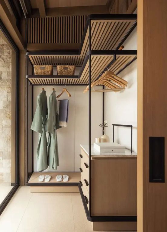 Offener Kleiderschrank mit Bügeln und Bademänteln im modernen Design