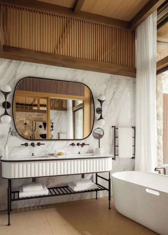 Luxuriöses Badezimmer mit freistehender Badewanne und großem Spiegel