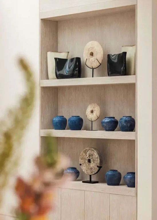 Elegantes Regal mit dekorativer Keramik und Skulpturen in der Ilios Villa