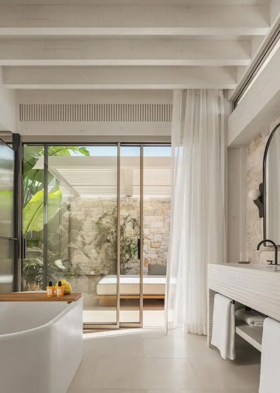 Modernes Badezimmer mit Glaswand und Blick auf den Innenhof