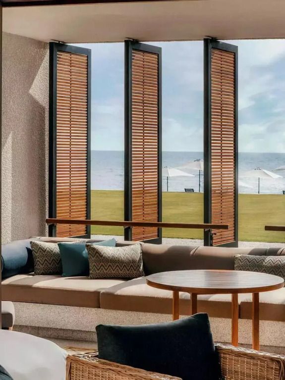 Eleganter Lounge-Bereich mit Blick aufs Meer durch Vertikallamellenfenster