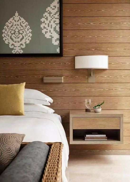 Elegantes Schlafzimmer mit Holzwandverkleidung und moderner Wandlampe