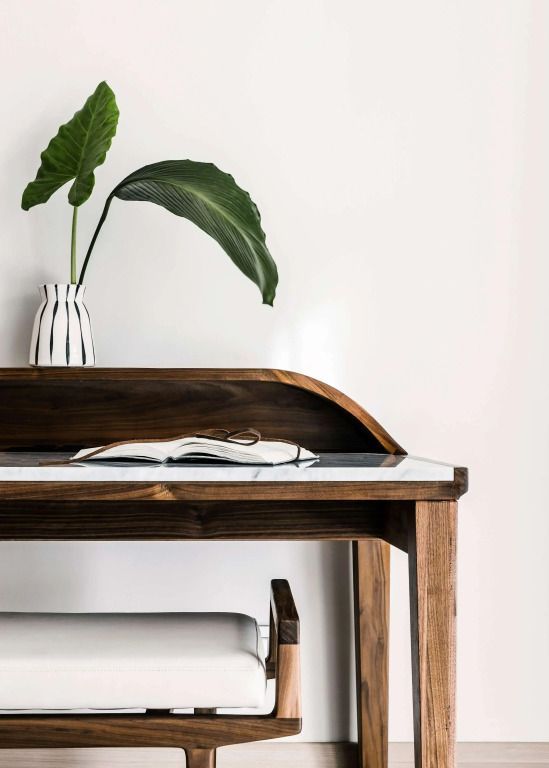 Eleganter Holztisch mit dekorativer Vase und offenem Buch in stilvoller Suite.