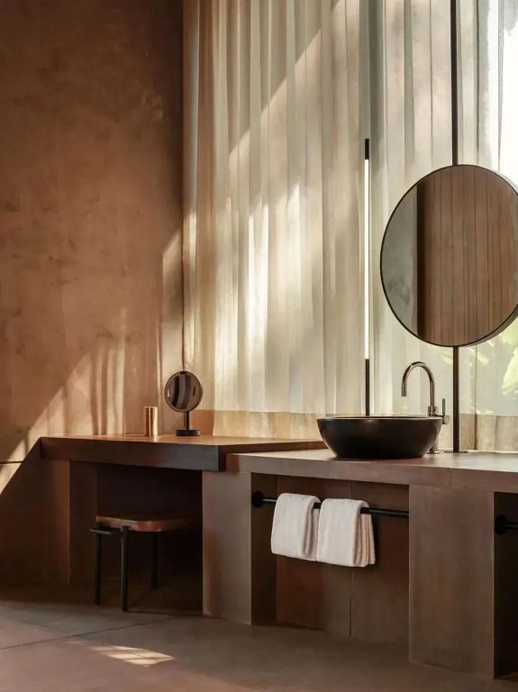 Modernes Badezimmer mit rundem Spiegel und minimalistischer Einrichtung