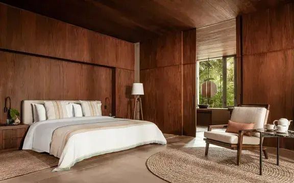 Luxuriöses Schlafzimmer mit Kingsize-Bett und Holzwandverkleidung