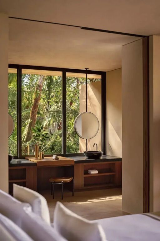 Elegantes Badezimmer mit Blick auf tropische Pflanzen durch große Fenster