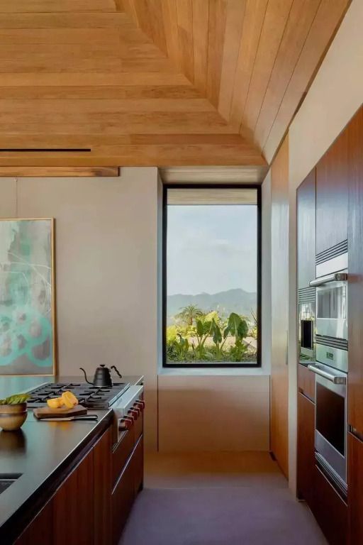 Moderne Küche mit Holzakzenten und Bergblick durch das Fenster