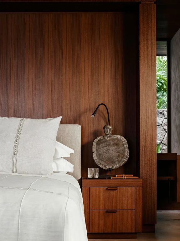 Luxuriöses Schlafzimmer mit Holzwand und stilvoller Beleuchtung im Ocean Doppel Treehouse.