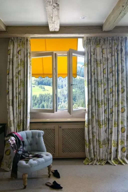 Offenes Fenster mit gelbem Vorhang und Blick auf die Alpinen Landschaften