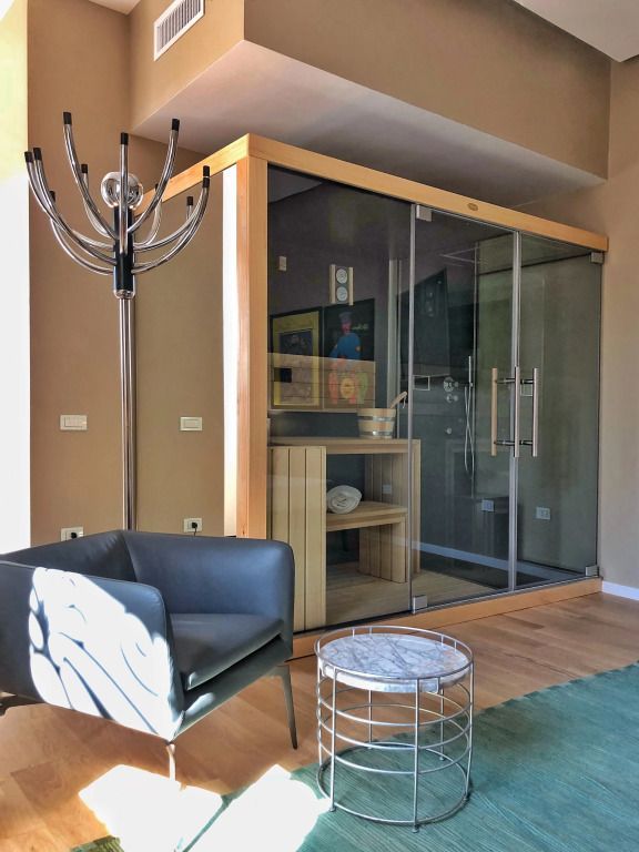 Elegante Suite mit moderner Sitzgelegenheit und großer Glasdusche.