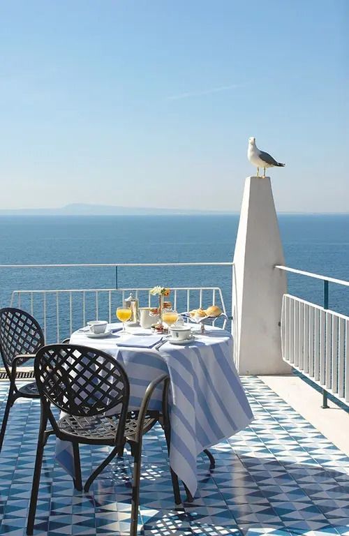 Meerblick von einem Balkon mit Frühstückstisch und Möwe