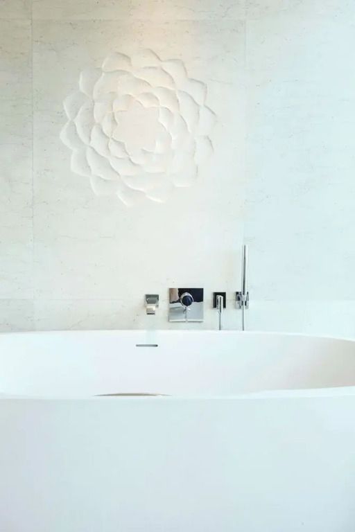 Freistehende Badewanne vor strukturierter Wand im Badezimmer