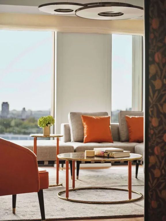 Wohnbereich mit grauem Sofa und großen Fenstern mit Stadtblick