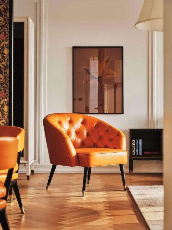 Eleganter Sessel in einer stilvollen Ecke der Suite mit modernem Kunstwerk an der Wand