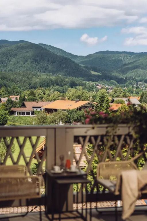 Balkonaussicht auf grüne Hügel und Architektur des Parkhotel Egerner Höfe.