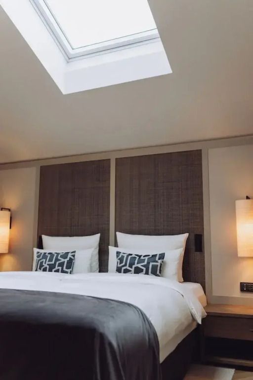 Luxus-Suite mit großem Doppelbett und eleganten Nachttischlampen
