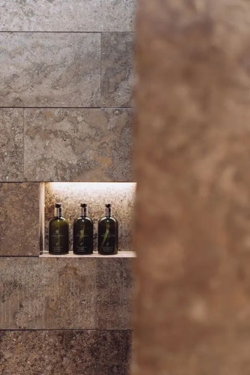 Dekorative Nische mit Flaschen im Badezimmer der Suite