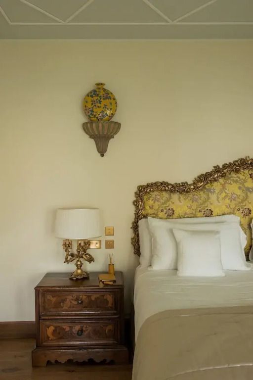 Dekoratives Bett mit kunstvollen Kissen und Nachttisch in einem eleganten Zimmer