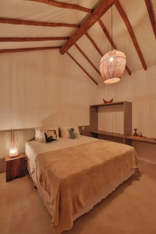 Gemütliches Schlafzimmer mit Holzbalkendecke und gedämpftem Licht