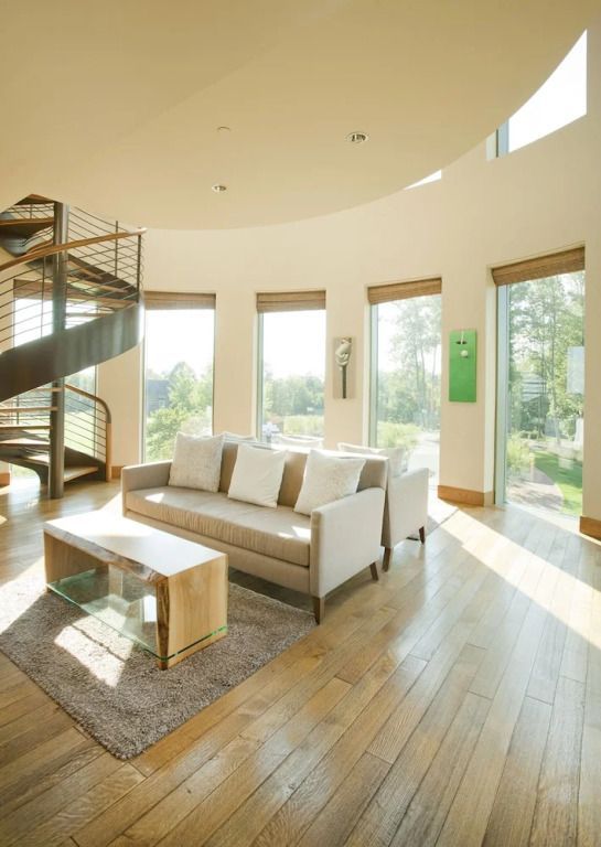 Helles Wohnzimmer mit Wendeltreppe und großen Fenstern