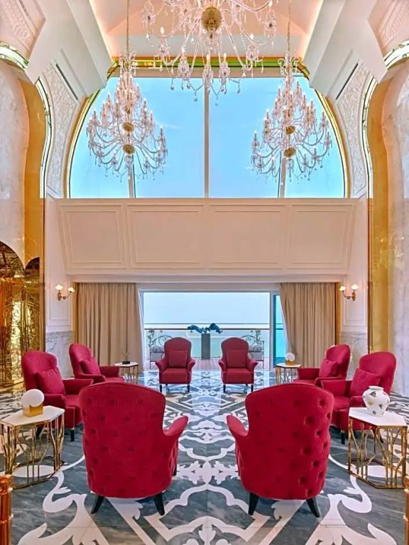 Prächtig dekoriertes Wohnzimmer der Royal Suite im Raffles Doha mit hohen Decken und Kronleuchtern