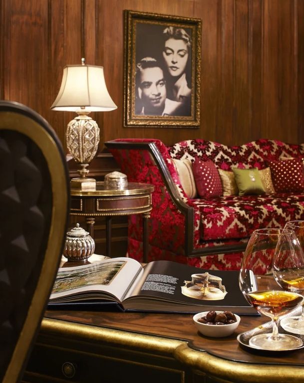 Elegante Lounge im Rambagh Palace mit kunstvollen Möbeln und Gemälden.