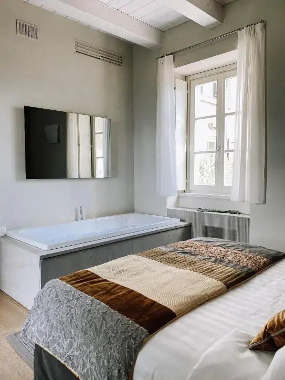 Luxuriöses Zimmer mit großem Fenster und flauschigem Bett in neutralen Tönen