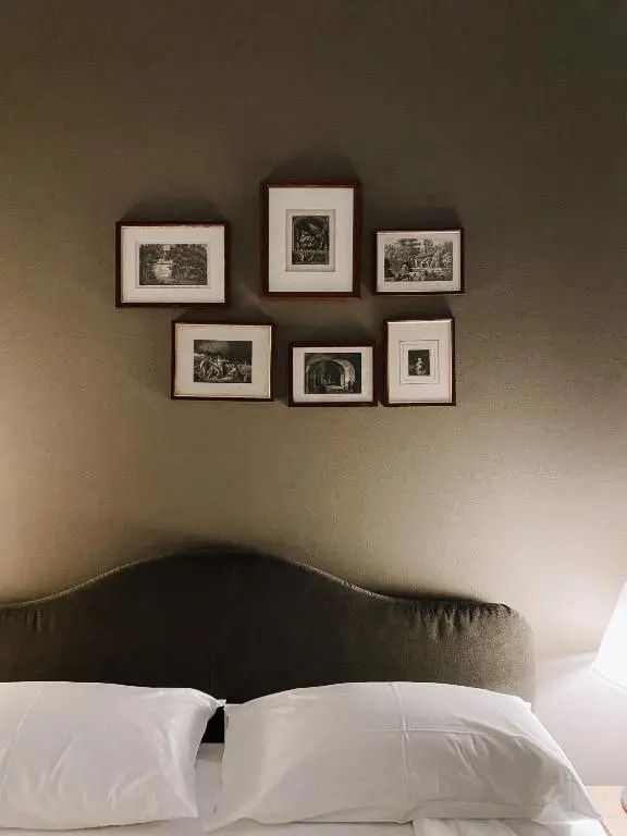 Kunstvolle Wanddekoration über einem bequemen Bett in einer Suite
