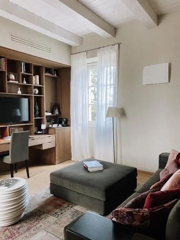 Gemütliches Wohnzimmer mit Büchern, einem Fernseher und großen Fenstern