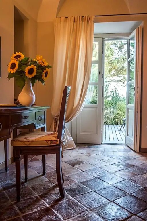 Hotelzimmer mit Blumen auf einem Tisch und Ausblick auf eine Terrasse im Relais San Maurizio.