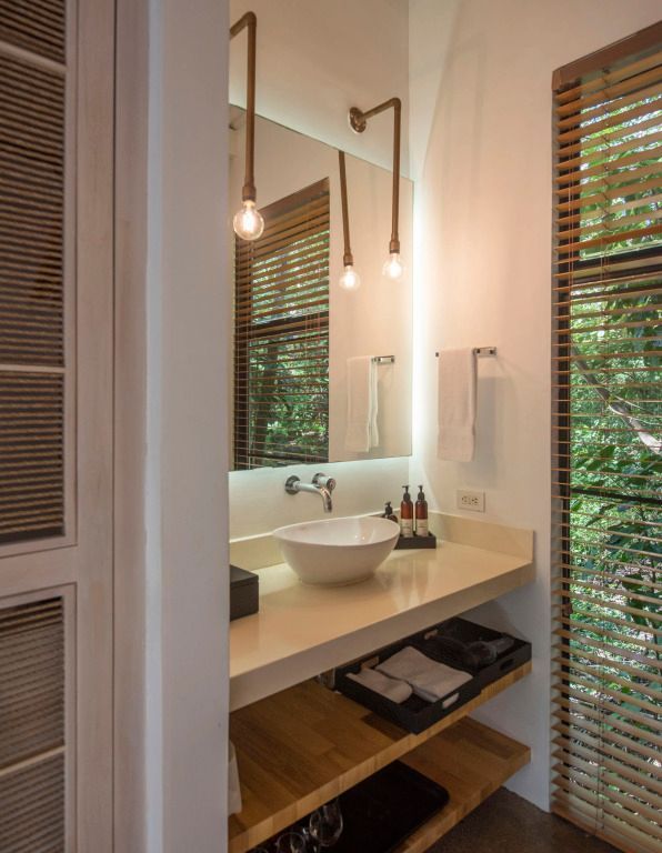 Elegantes Badezimmer mit großem Spiegel und modernen Leuchten