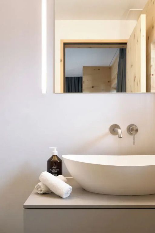 Modernes Badezimmer mit stylischem Waschbecken und schlichter Einrichtung.
