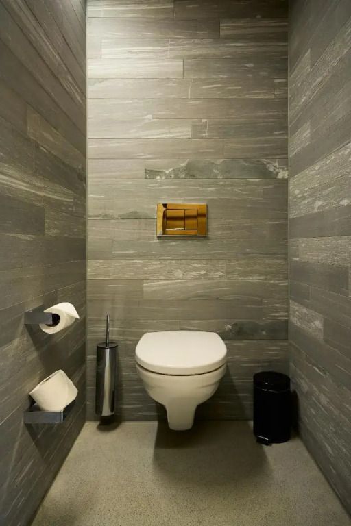 Modernes Badezimmer mit grauen Fliesen und hängender Toilette